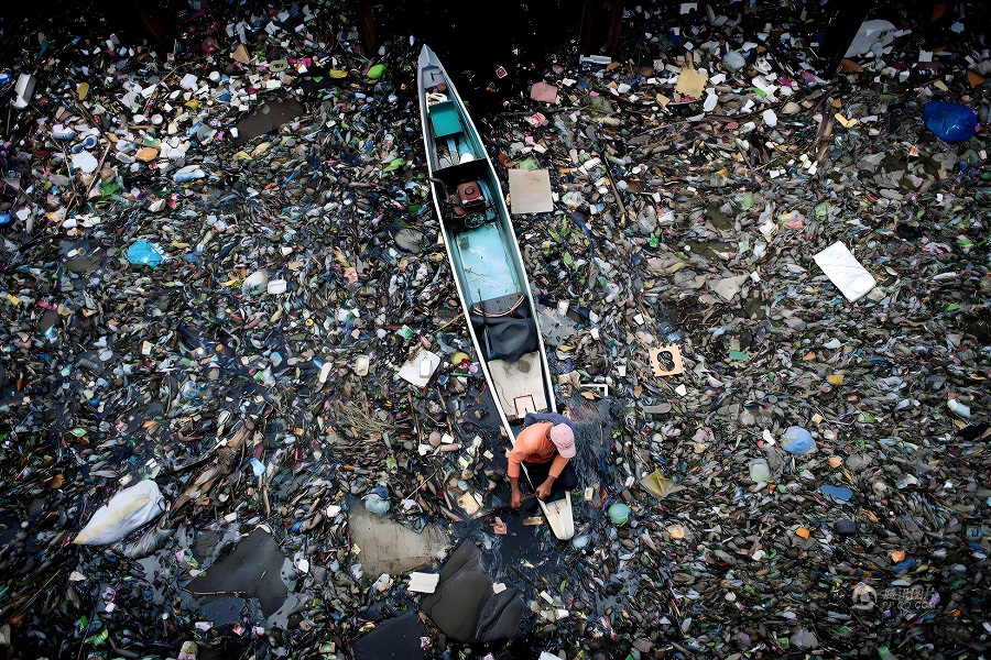 The boat floated in a polluted river full of rubbish